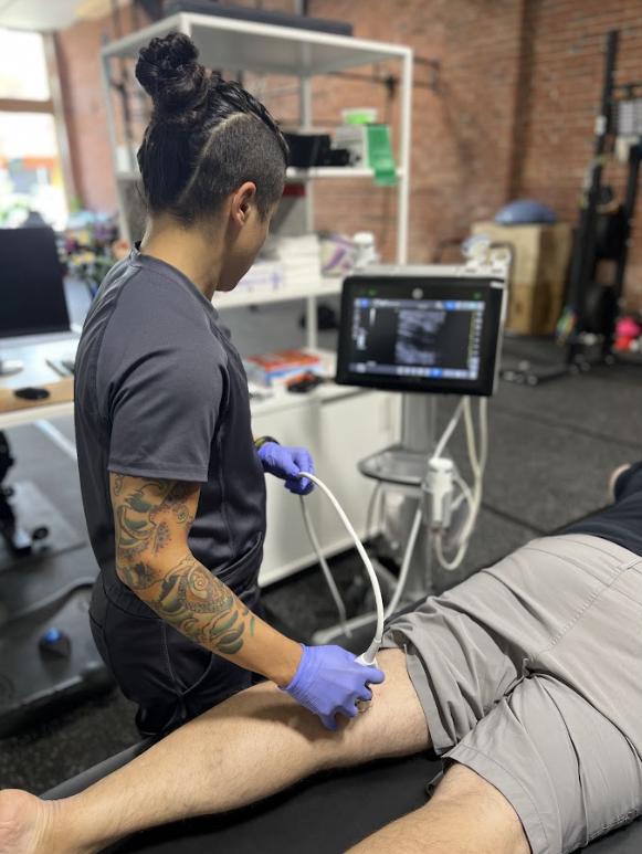 Physician performing diagnostic musculoskeletal ultrasound for injury assessment in Tacoma