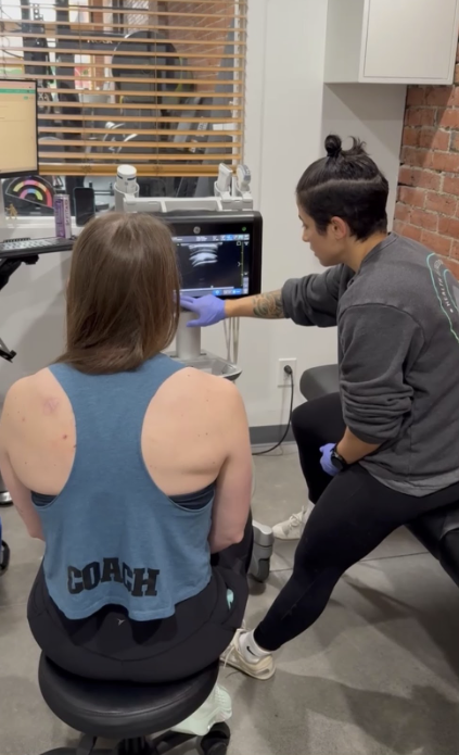 Sports medicine physician explaining ultrasound-guided treatment plan to patient