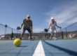 Active adult playing pickleball and performing a lateral movement that can stress the knees and calves.